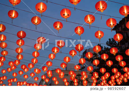 Red chinese lanterns hanging on wire outdoor lamps in temple of China Town decoration on Chinese New Year festival culture with blue sky at night background in Asia. 98592607