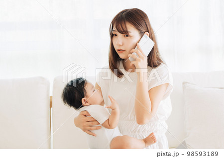 赤ちゃんの病気で病院に電話をするお母さん 98593189