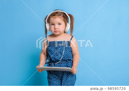 Beautiful cute happy little girl with headphones 98595720