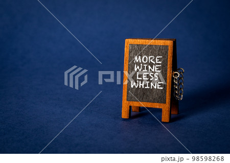 More Wine Less Whine. Miniature chalkboard on a blue background More Wine Less Whine. Miniature chalkboard on a blue background 98598268
