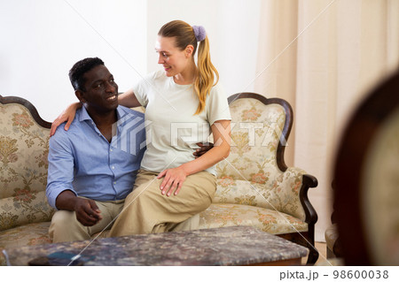 Portrait of happy couple on luxurious sofa in room Portrait of happy couple on luxurious sofa in room 98600038