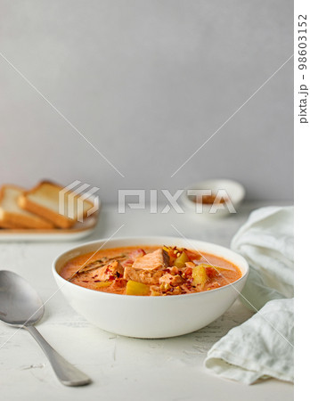 bowl of salmon and tomato soup 98603152