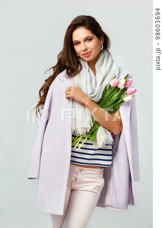 Fashion photo of beautiful woman with tulips in her hand. March 8. beautiful girl in stylish clothes Fashion photo of beautiful woman with tulips in her hand. March 8. beautiful girl in stylish clothes 98603694