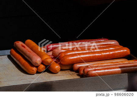 Fresh grilled long meat sausages on grill at food market - close up Fresh grilled long meat sausages on grill at food market - close up 98606020