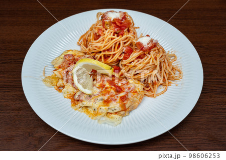 Chicken breast in Portuguese sauce with cheese and spaghetti on plate on wooden background. Chicken breast in Portuguese sauce with cheese and spaghetti on plate on wooden background. 98606253