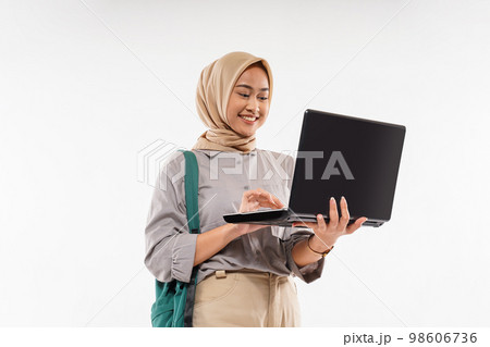 a female student with hijab standing opened the laptop at her hand 98606736