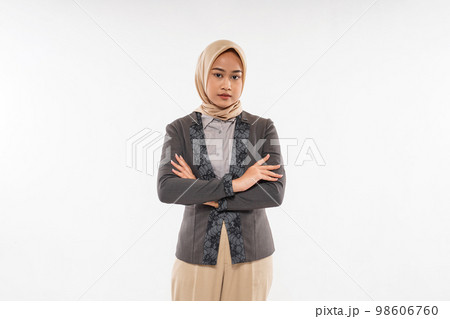 woman with hijab standing with solemn expression and crossed her hands woman with hijab standing with solemn expression and crossed her hands 98606760