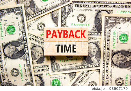 Payback time symbol. Concept words Payback time on wooden blocks. Beautiful background from dollar bills. Business and payback time concept. Copy space. Payback time symbol. Concept words Payback time on wooden blocks. Beautiful background from dollar bills. Business and payback time concept. Copy space. 98607179