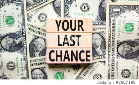 Time to your last chance symbol. Concept words Your last chance on wooden blocks on a beautiful background from dollar bills. Business and your last chance concept. Copy space. 98607196