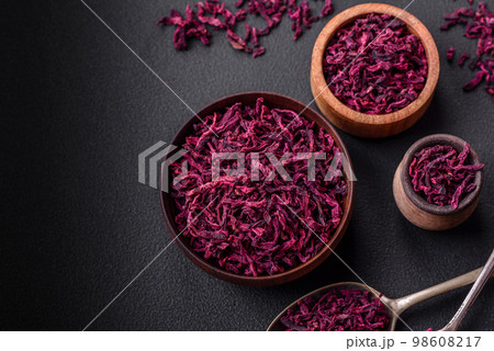 Dried beets in small slices in a wooden bowl on a black concrete background 98608217
