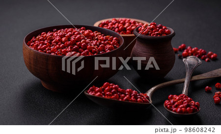 Spice, allspice peas of red or pink color in a wooden bowl Spice, allspice peas of red or pink color in a wooden bowl 98608242