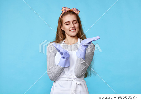 woman in rubber gloves and cleaner apron looking at camera woman in rubber gloves and cleaner apron looking at camera 98608577