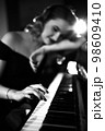 Hand of a girl with colored finger nails playing the piano. soft focus 98609410