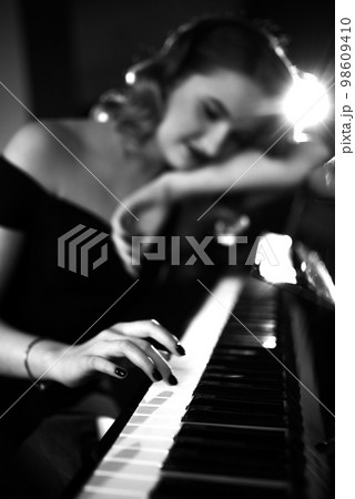 Hand of a girl with colored finger nails playing the piano. soft focus 98609410