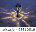 雪の中で幻想的に光るガーデンライト 98610619