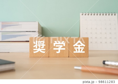 奨学金と書かれたブロックが置かれたデスク 98611283
