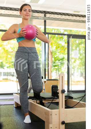 Positive girl doing exercises with pilates ball in gym Positive girl doing exercises with pilates ball in gym 98611635
