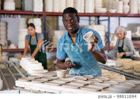 African american artisan having ceramics in hands and standing in workshop 98611694