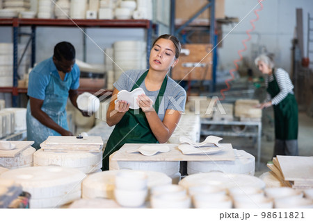 Young woman potter with new crafted decorative plates 98611821