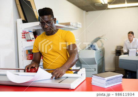 Employee of printing house checks the quality of printing in computer room Employee of printing house checks the quality of printing in computer room 98611934