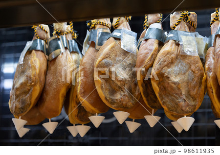 Suspended smoked meat behind a glass case at the market Suspended smoked meat behind a glass case at the market 98611935