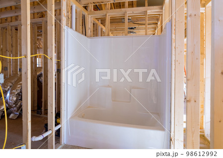Unfinished bathroom under construction home with installed bathtub in new house Unfinished bathroom under construction home with installed bathtub in new house 98612992