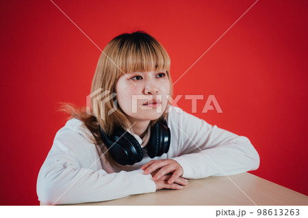 ヘッドホンを首にかける女性 98613263