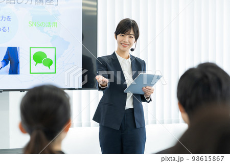 モニターの前で話をする女性講師 ビジネスセミナー モニターの前で話をする女性講師 ビジネスセミナー 98615867