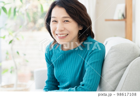 ソファでくつろぐミドル女性 98617108