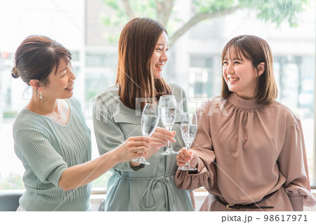 女子会でレストラン・カフェ・飲食店でシャンパンを持って乾杯する女性達（アジア人） 98617971