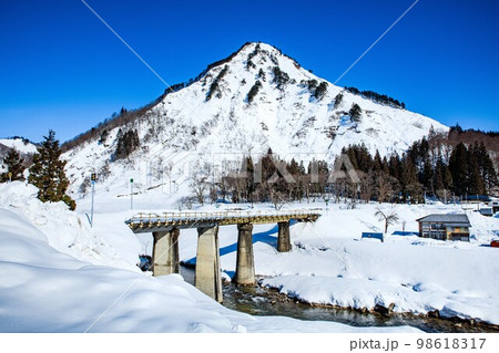 雪に覆われる只見線の真奈川橋梁と蒲生岳(福島県只見町、1月) 98618317