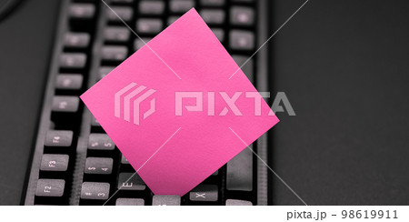 Colored sticker lying on black keyboard. Important information written over paper. Image with school supplies. Multiple Assorted Collection Office Stationery. Colored sticker lying on black keyboard. Important information written over paper. Image with school supplies. Multiple Assorted Collection Office Stationery. 98619911