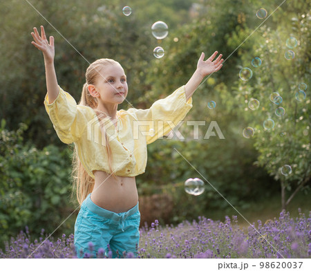 Beautiful little girl in a field with lavender. 98620037