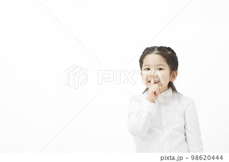 内緒のポーズをとっている白背景の子供の女の子 98620444