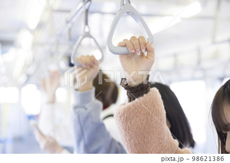 電車でつり革につかまる若い女性手元 98621386