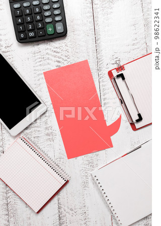 Color paper in shape of dialog box with important message. Infromation written on sticker. Different office stationery. Calculator, pencils, pens laing white table. Color paper in shape of dialog box with important message. Infromation written on sticker. Different office stationery. Calculator, pencils, pens laing white table. 98622341