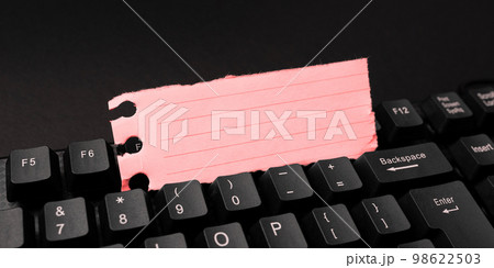 Colored sticker lying on black keyboard. Important information written over paper. Image with school supplies. Multiple Assorted Collection Office Stationery. 98622503