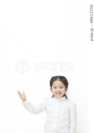 右手を上に上げて、案内をしている白背景の子供の女の子 98623356