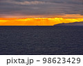 海面にかざす夕刻の日差し 98623429