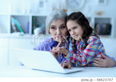 portrait of grandmother and daughter using laptop 98623707
