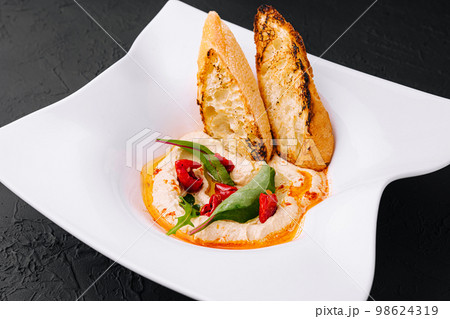 hummus with toasted baguette croutons on plate hummus with toasted baguette croutons on plate 98624319