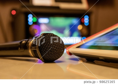 テーブルの上にカラオケのマイクとリモコンが置いてある画像 98625165