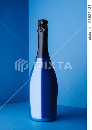 Blue Champagne bottle on light blue background Blue Champagne bottle on light blue background 98625481