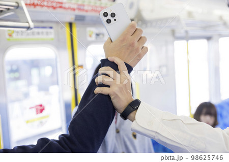 電車で盗撮犯を捕まえる女性手元 98625746
