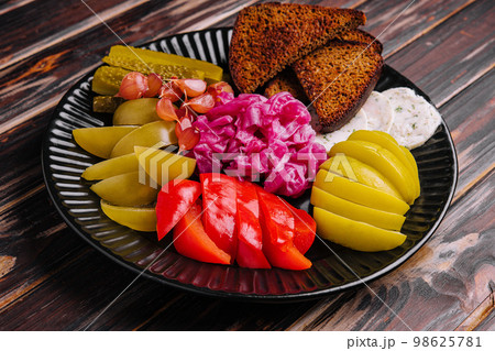 Pickles, cabbage, peppers, bread and garlic spread on a plate Pickles, cabbage, peppers, bread and garlic spread on a plate 98625781