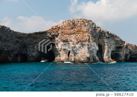 Tourist on yacht explore natural stone arches and caves. Malta Tourist on yacht explore natural stone arches and caves. Malta 98627410