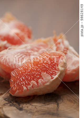 Peeled grapefruit on olive serving board Peeled grapefruit on olive serving board 98628149