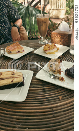 Vertical shot of eating traditional german Christmas stollen cake or Christstollen and other cakes together at a cafe Vertical shot of eating traditional german Christmas stollen cake or Christstollen and other cakes together at a cafe 98629732