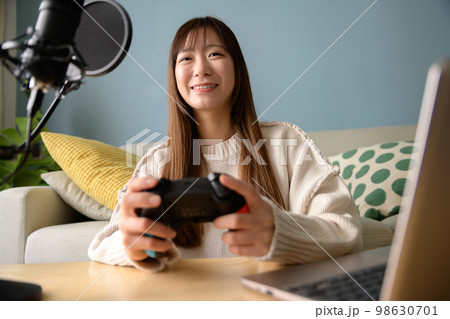 パソコンとマイクでゲーム配信する女性　ゲーム女子　ゲーム実況　ユーチューバー　 98630701