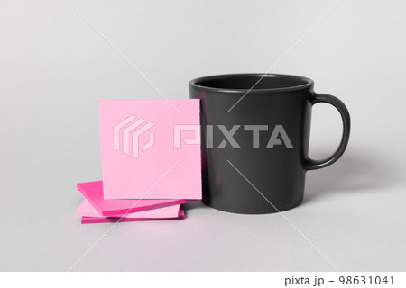 Coffee Cup Standing on Desk. Important infrormation written on paper. Different Office Supplies, Pencils, Pens, Marckers. Computer keyboard. Text on wood table. 98631041